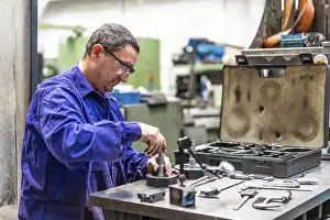 Factory Worker Stampe: Factory worker operator in the numerical control sector checking the equipment