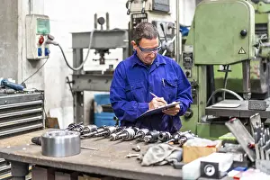 Factory Worker Stampe: Factory worker operator in the numerical control sector making a report