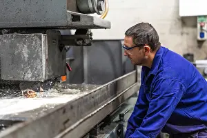 Factory Worker Stampe: Factory worker operator in the numerical control sector preparing a machine