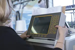 Modern Industrial Architecture Stampe: Female operator setting programme at knitting machine control panel view