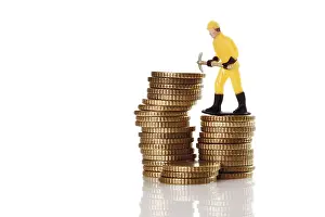 Symbolic Construction Image Stampe: Figure of a construction worker with hard hat and pickaxe on a stack of coins
