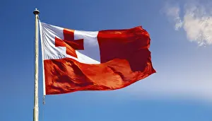 Stampe di La bandiera delle Isole Tonga, che fluttua nel vento, isolata, contro il cielo azzurro Tonga Stampe: Il vessillo della Tonga, che fluttua nel vento.