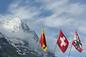 Swiss National Flag Stampe: Flags in front of the snow-covered Eiger Mountain