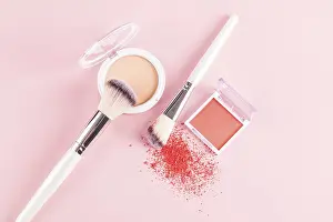 Beauty Tools Stampe: A flat lay of makeup essentials featuring a compact blush with two makeup brushes