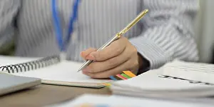 Office Communication Skills Stampe: A focused professional writes notes in a notebook
