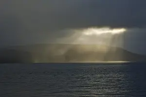 Deserted Icelandic Coastline Stampe: Gap in the clouds with sun shining through