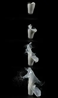 Healthy Eating Symbolism Stampe: Glass for Milk exploding against Black Background