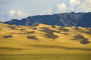 Stampe di Dune di sabbia pittoresche e gradualmente inclinate del deserto mongolo Gobi e della catena montuosa a Khongor Els nella Mongolia meridionale Immagini Correlate Stampe: Inclinante gradualmente