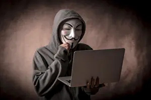 Hacker Anonymous Mask Stampe: Hacker with anonymous mask with a laptop thinking about programming