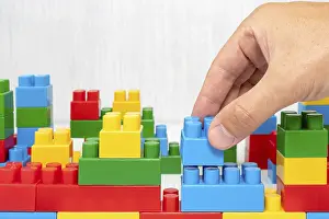 Deserted Construction Site Stampe: Hand building up a wall by stacking up block