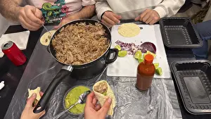 Traditional Mexican Cuisine Stampe: Hands preparing and assembling carnitas tacos with pulled pork