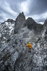 Hiker In The Alps Stampe: Hiker looking at mountains under dramatic clouds