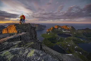 Hiking In Norway Stampe: Two hikers at the summit, sunset with dramatic clouds