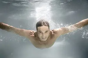 One Person Swimming Stampe: An image of a man diving in a pool