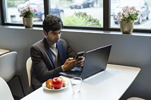Remote Work Lifestyle Stampe: A indian man multitasks efficiently using a smartphone