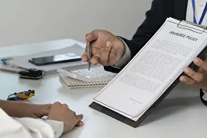 One Person Working Stampe: An insurance agent presenting a policy document to a client