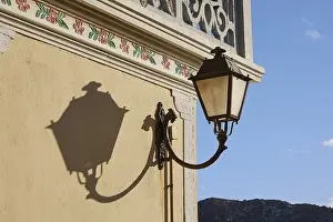 Ornate Building Exterior View Stampe: Lantern casts a shadow on a yellow