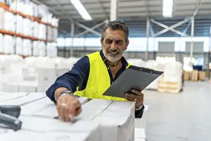 Barcode Scanner Stampe: Logistics manager smiling while using a barcode scanner