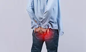 Abdominal Pain Causes Stampe: Man with digestive problem touching his buttock