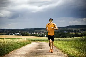 Fitness Man Stampe: Man jogging through the fields