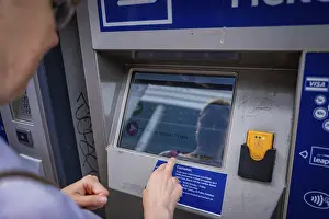 European Urban Environment Images Stampe: Man operates a ticket machine and is reflected in the display