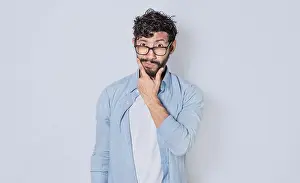 Hispanic Ethnicity Model Stampe: Man rubbing his beard with an expression of doubt