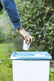 Environmental Protection Stampe: Man throwing up garbage bin