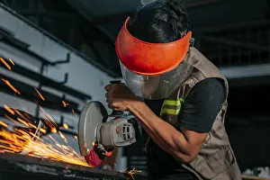 Handicraft Industry Stampe: Man using a grinder in a workshop