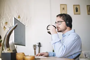 Businessman At Work Stampe: Man working computer drinking