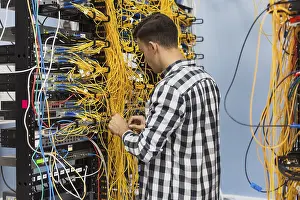Fibre Optic Cable Stampe: Man working ethernet switch