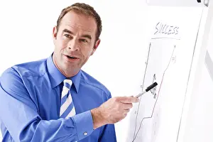 Communication Skills Training Stampe: Manager explaining something by using a flipchart