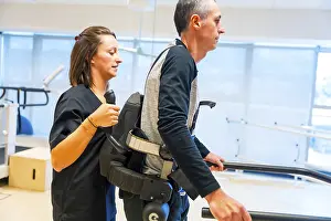 Physical Disability Support Stampe: Mechanical exoskeleton. Female physiotherapy medical assistant helping disabled person with robotic skeleton to walk