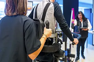 Physical Therapy Exercises Stampe: Mechanical exoskeleton. Female physiotherapy medical assistant helping disabled person with robotic skeleton to walk
