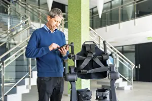 Mechanical Exoskeleton Stampe: Mechanical exoskeleton computer engineer looking at the robot with a tablet