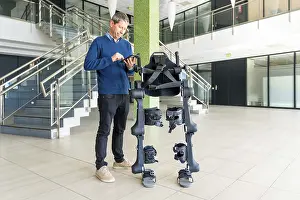 Exoskeleton Technology Stampe: Mechanical exoskeleton computer engineer looking at the robot with a tablet