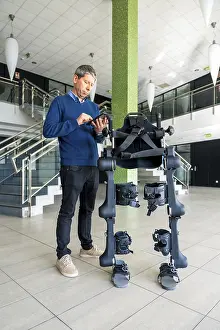 Mechanical Exoskeleton Stampe: Mechanical exoskeleton computer engineer looking at the robot with a tablet