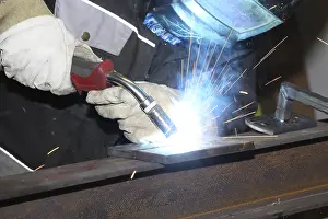 Industrial Equipment Stampe: Metalworker during welding work in his workshop