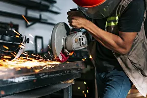 Handicraft Industry Stampe: Metalworking professional using an angle grinder in the workshop