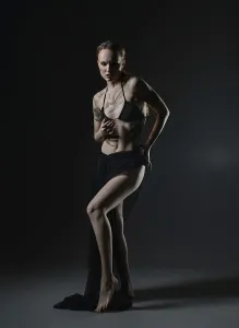 Confident Model Pose Stampe: A model stands confidently in a dark studio