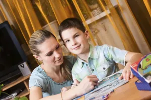 Child Learning At Home Stampe: Mother and boy doing homework together and posing