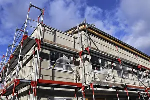 Residential Construction Site Stampe: New building with completed basic rendering of the exterior facade New building with completed basic rendering of