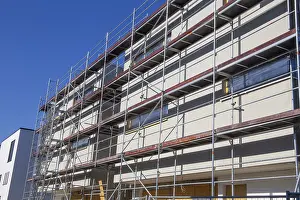 Residential Construction Site Stampe: New building with completed basic rendering of the exterior facade New building with completed basic rendering of