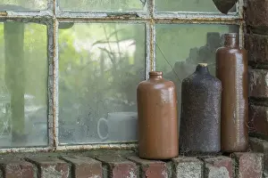 Ceramic Decorative Items Stampe: Three old earthenware bottles in front of a stable window
