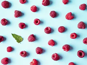 Flat Lay Fruit Photography Stampe: Pattern of ripe red raspberry on blue background