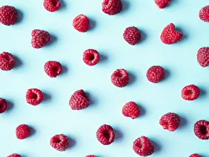 Flat Lay Fruit Photography Stampe: Pattern of ripe red raspberry on blue background