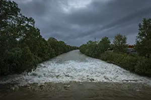 Uninhabited Waterfront Stampe: A powerful river with a strong current under a cloudy sky