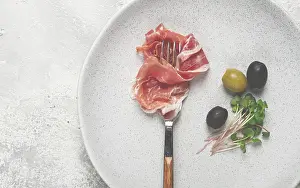 Gourmet Meal Idea Stampe: Prosciutto on a fork, top view