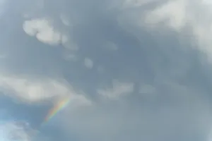 Multicolored Cloudy Skies Stampe: Rainbow appears in rain clouds in spring