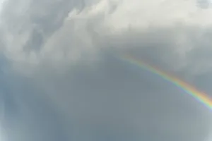 Cloudy Sky With Rainbow Colors Stampe: Rainbow appears in rain clouds in spring