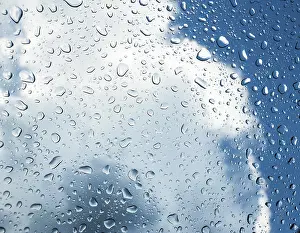 Raindrops On Window Stampe: Raindrops on a window in front of storm clouds